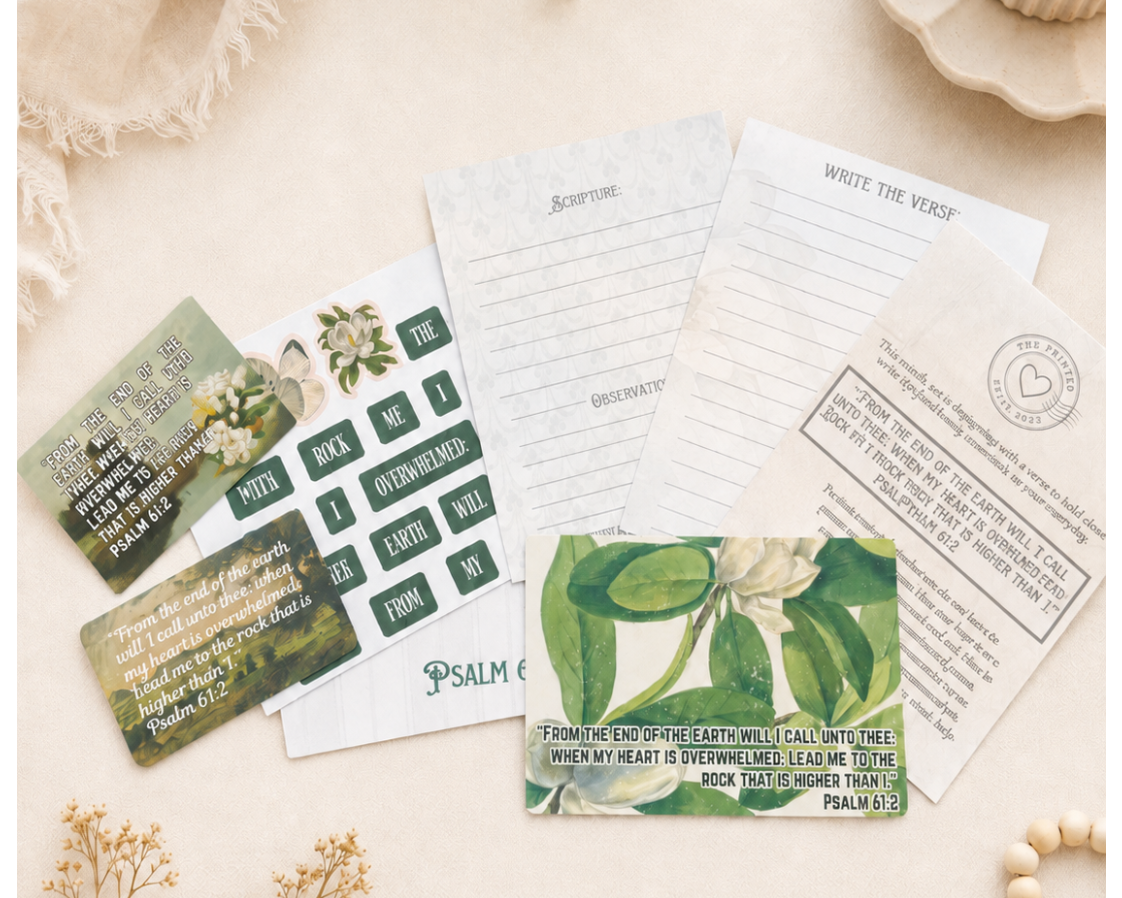 A styled flat-lay of a Bible study or prayer card set on a warm cream fabric background, surrounded by dried flowers, a lit candle, and wooden beads. The set includes printed cards with scripture verses, a writing guide, and a green botanical-themed card.